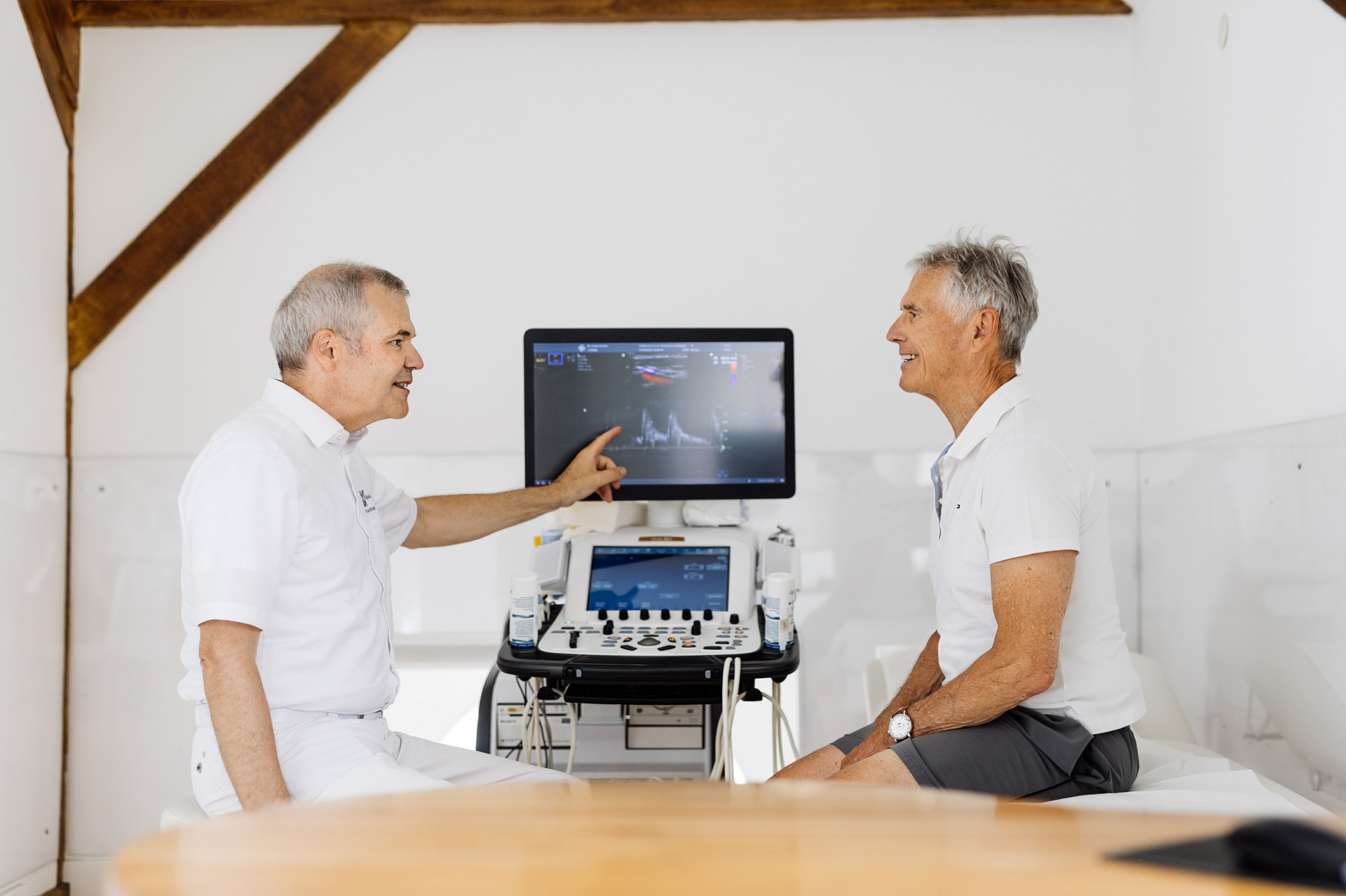 Doctor shows patient the ultrasound images on the monitor