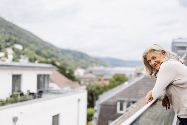 patient stands on balcony and looks happily into the distance